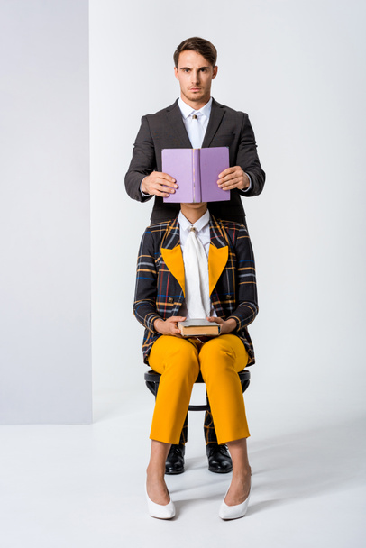 stylish man covering face of woman while holding book on white  - Foto, immagini