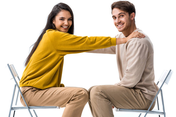 happy girl sitting on chair and touching man on white  - 写真・画像