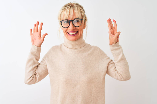 Middle age woman wearing turtleneck sweater and glasses over isolated white background showing and pointing up with fingers number eight while smiling confident and happy. - Photo, Image
