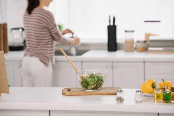 szelektív fókusz tál friss zöldség saláta és a nő főzés kávé gejzír kávéfőző - Fotó, kép