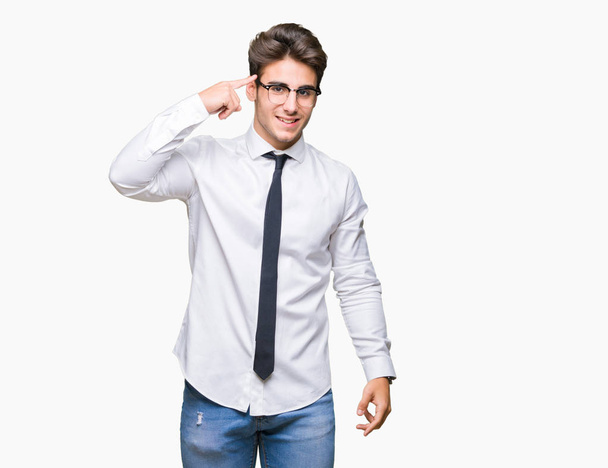 Young business man wearing glasses over isolated background Smiling pointing to head with one finger, great idea or thought, good memory - Foto, afbeelding