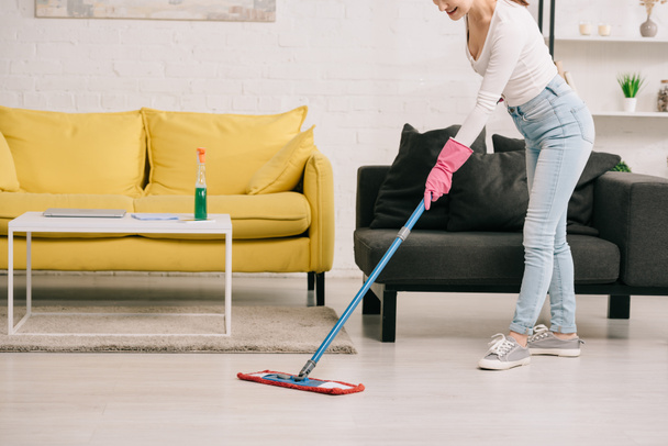 cropped view of housewife washing floor with mop near yellow and grey sofas - Fotoğraf, Görsel