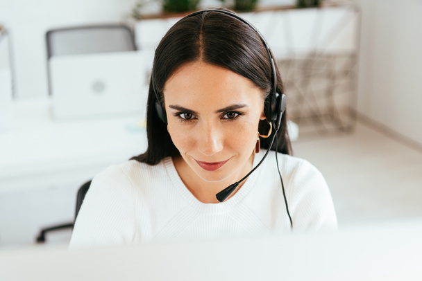 selective focus of attractive broker in headset working in call center  - Photo, Image