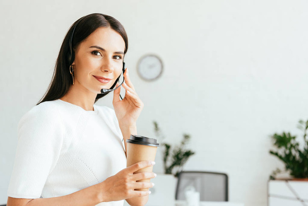 happy broker touching headset and holding paper cup  - Photo, image