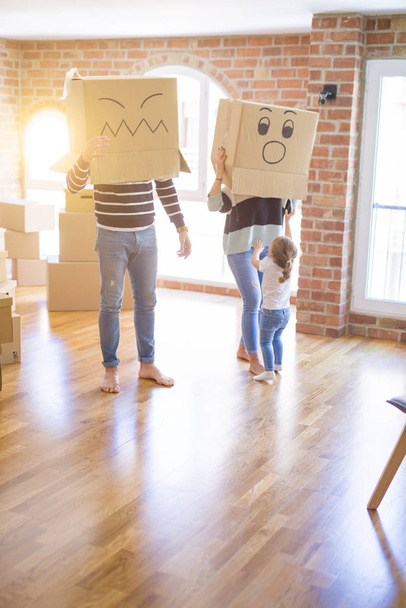 Прекрасная семья с ребенком, играющим с картонными коробками в новом доме
 - Фото, изображение