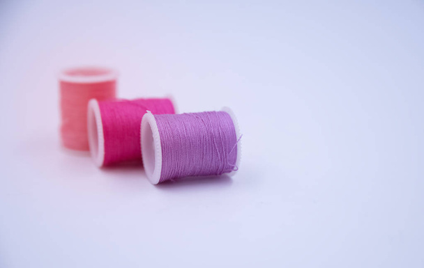 In selective focus of soft purple color thread put on white background,blurry light around - Foto, Imagem