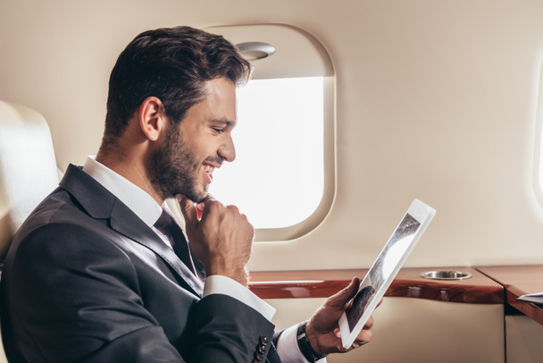 bel homme d'affaires en costume en utilisant une tablette numérique dans un avion privé
  - Photo, image