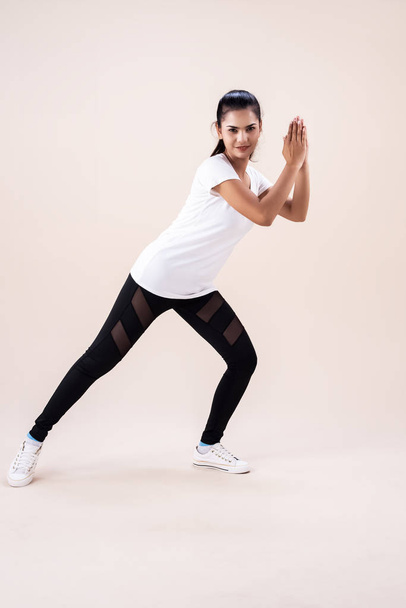 die junge Frau beim Zumba-Dance-Workout, indem sie in die Hand klatscht und den Zeh nach unten zeigt, Grundmuster für die Übung, - Foto, Bild