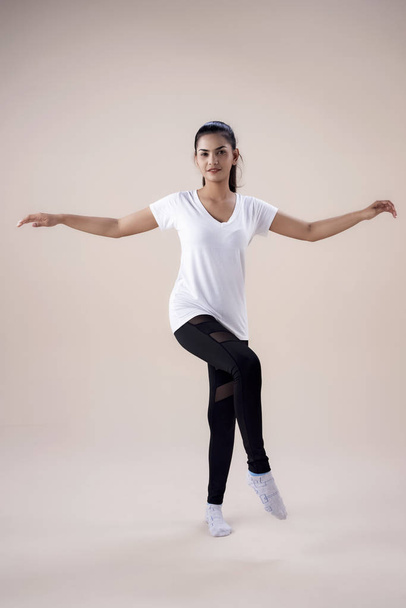 La jeune femme qui fait de l'entraînement de danse Zumba, lève les mains et pointe les orteils dans les airs, montre le modèle de base pour l'exercice
, - Photo, image