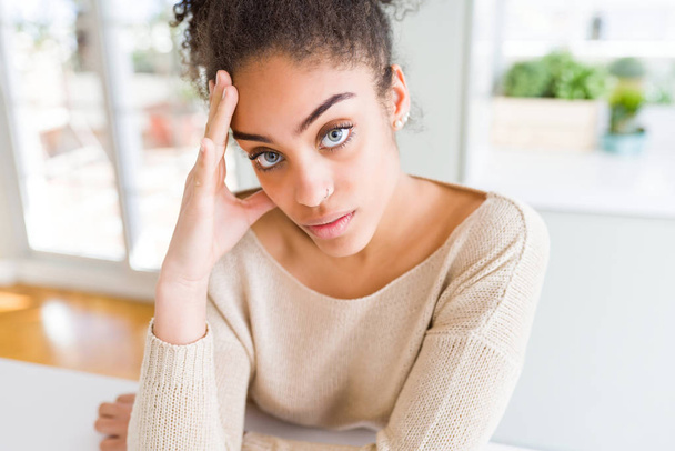 Красива молода афроамериканець жінка з блакитними очима, відпочиваючи вдома, з впевненим вираз на обличчі - Фото, зображення
