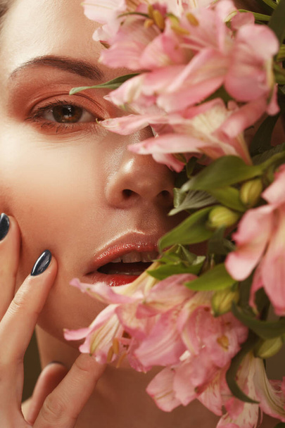 beautiful young woman with makeup in gentle colors holds a big pink flowers - 写真・画像