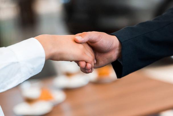 cropped view of woman shaking hands with man  - Fotoğraf, Görsel