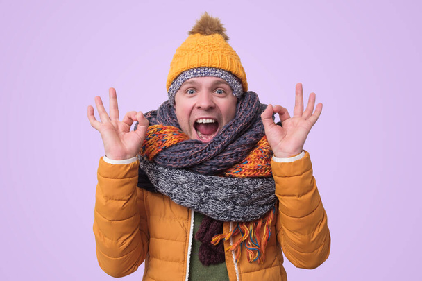 Handsome caucasian funny man in several hats and scarfs. - Photo, Image
