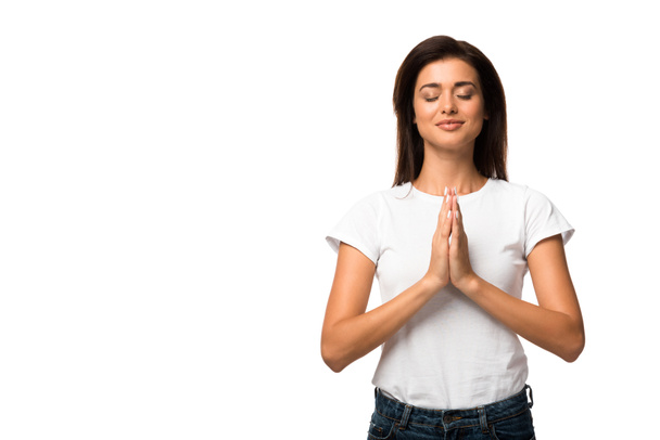 attractive woman in white t-shirt praying with hands folded together, isolated on white - 写真・画像