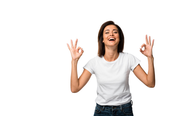 laughing woman in white t-shirt showing ok signs, isolated on white - Foto, afbeelding