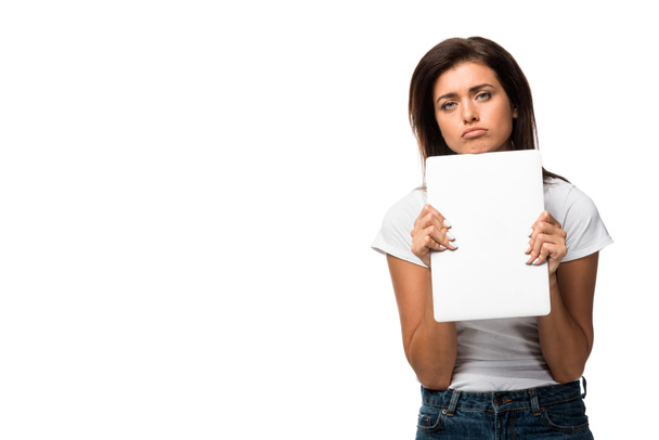 beautiful upset young woman holding laptop, isolated on white - Фото, изображение