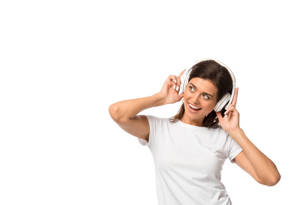 cheerful young woman listening music with headphones, isolated on white - Valokuva, kuva