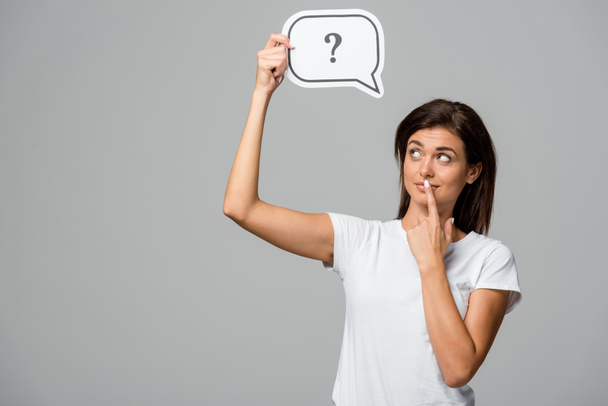 thoughtful woman holding speech bubble with question mark, isolated on grey - Photo, Image