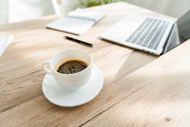 fermer la tasse de café et ordinateur portable sur la table dans le bureau léger
 - Photo, image