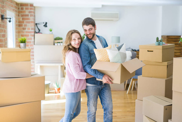 Young beautiful couple very happy together holding cardboard box - Photo, Image