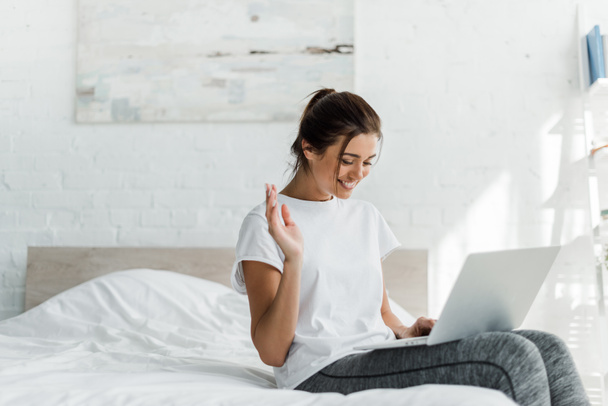 beautiful cheerful woman using laptop in bed in the morning  - Valokuva, kuva