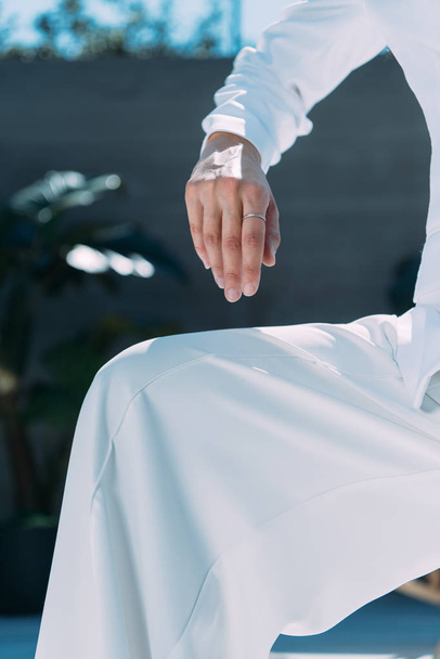 обрізаний вид жінки в білому костюмі позує зовні
  - Фото, зображення