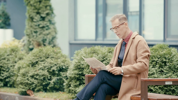 επιχειρηματίας σε παλτό ανάγνωση εφημερίδα  - Πλάνα, βίντεο