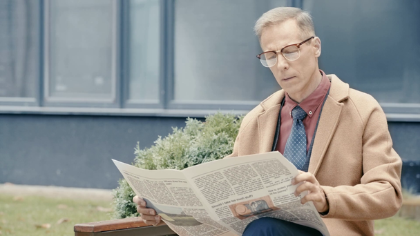 üzletember kabátban újságot olvas  - Felvétel, videó
