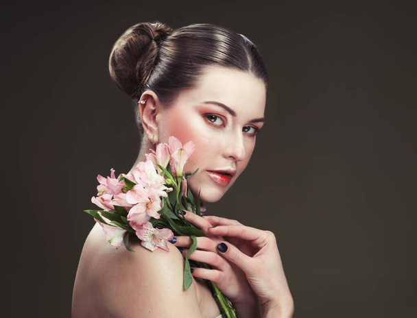 beautiful young woman with makeup in gentle colors holds a big pink flower, beauty concept - Fotografie, Obrázek