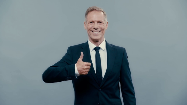 smiling businessman in suit showing thumb up  - Video, Çekim