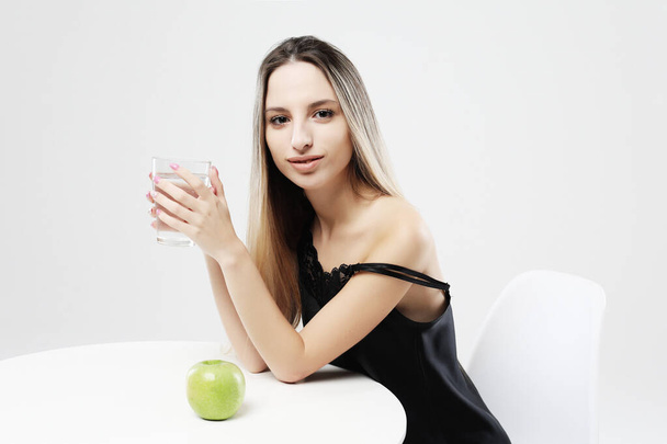 lifestyle, health and people concept - young woman wearing pajamas holding water glass - Foto, Imagen