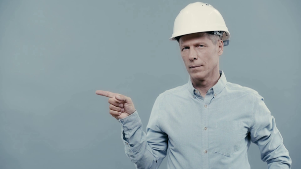 architekt w kasku wskazujący palcem na przestrzeń do kopiowania - Materiał filmowy, wideo