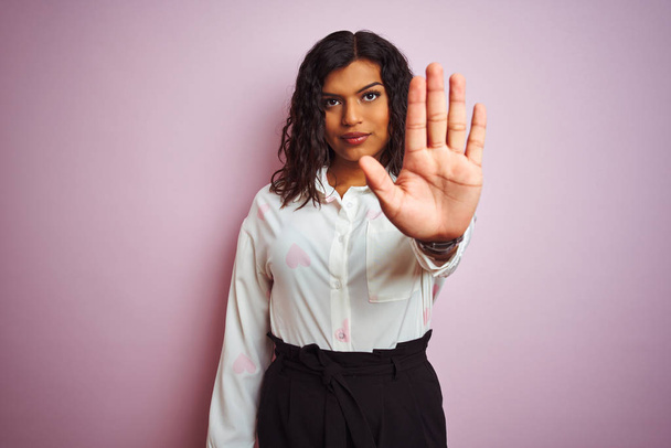 孤立したピンクの背景の上に立つトランスセクシャルトランスジェンダーの実業家は、手の手のひらで歌うのをやめます。顔に負と深刻なジェスチャーで警告式. - 写真・画像