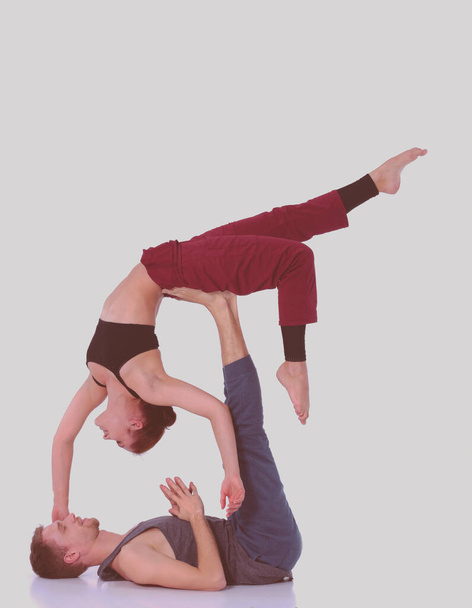 Young athletic couple practicing acroyoga. Balancing in pair. - Valokuva, kuva