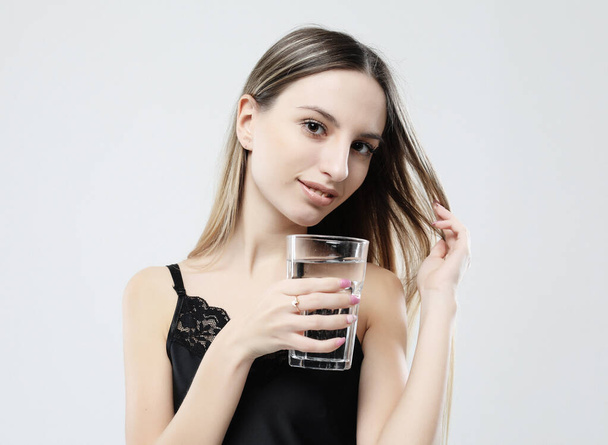 lifestyle, health and people concept - young woman wearing pajamas holding water glass - Fotografie, Obrázek
