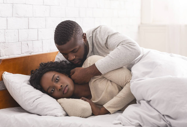 Schwarze Frau ignoriert Mann im Bett und weigert sich, Liebe zu machen - Foto, Bild