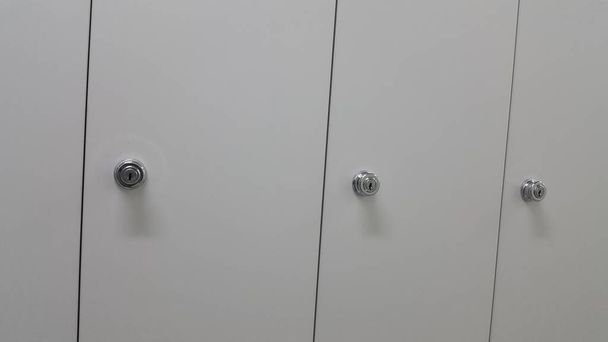 Перспективный вид шкафчиков или шкафов в ряд с белыми дверями
 - Фото, изображение