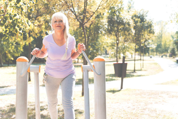 Senior woman doing exercise in park, healthy lifestyle concept - Fotoğraf, Görsel
