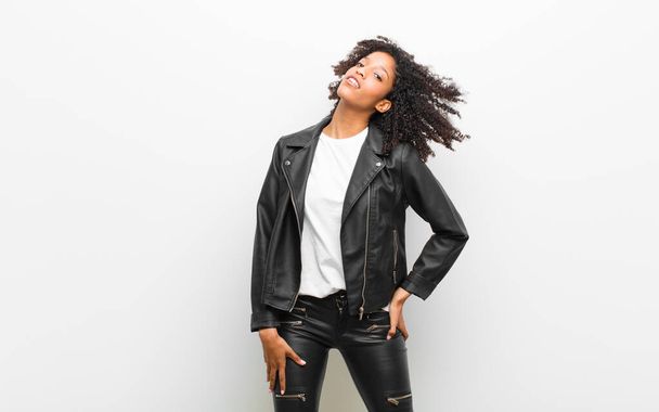 young pretty black woman wearing a leather jacket against white wall - Fotografie, Obrázek
