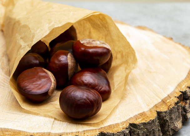 fresh clean shiny chestnuts in paper wrapping. - Photo, Image