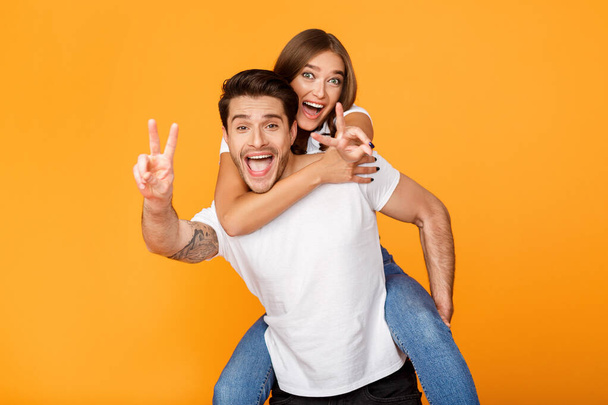 Freedom and fun. Playful couple gesturing peace signs - Фото, изображение