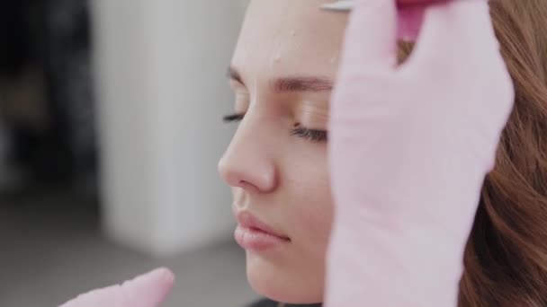 professionelle Make-up-Artist tut Augenbrauen-Markup für Client-Mädchen. - Filmmaterial, Video