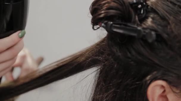 Friseurmädchen trocknet dem Kunden beim Friseur mit Haartrockner die Haare. - Filmmaterial, Video
