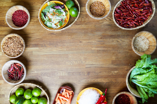 Верхний вид фонового изображения различных специй и пищевых ингредиентов, накрытых на деревянный стол с местом для копирования в центре
 - Фото, изображение