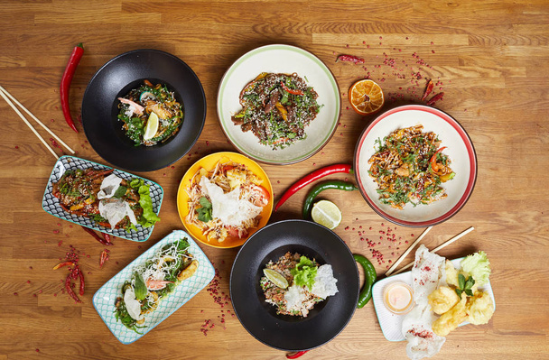 Top view tausta kauniita aasialaisia ruokia asetettu puinen pöytä koristeltu kuuma punainen paprika ja lime, kopioi tilaa
 - Valokuva, kuva