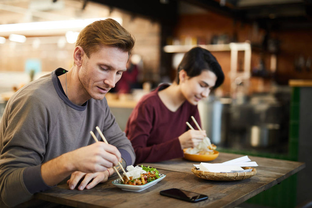 Retrato de personas disfrutando de deliciosa comida asiática mientras están sentadas en la mesa en la cafetería o el restaurante, espacio para copiar
 - Foto, Imagen