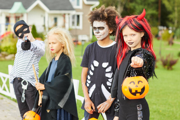 Grupo de crianças truque ou tratamento no Halloween, todos vestindo trajes enquanto posando ao ar livre
 - Foto, Imagem