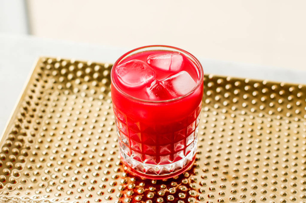 Бокал красного коктейля со льдом, роскошная вечеринка в баре
 - Фото, изображение