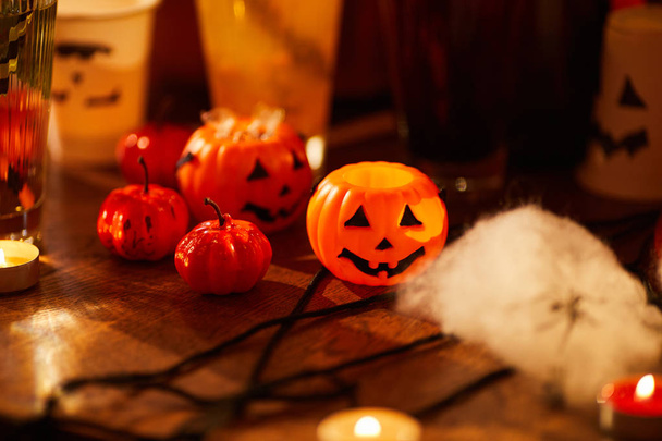 Background image of Halloween decorations, closeup of pumpkins and candles set on table for party, copy space - Photo, Image