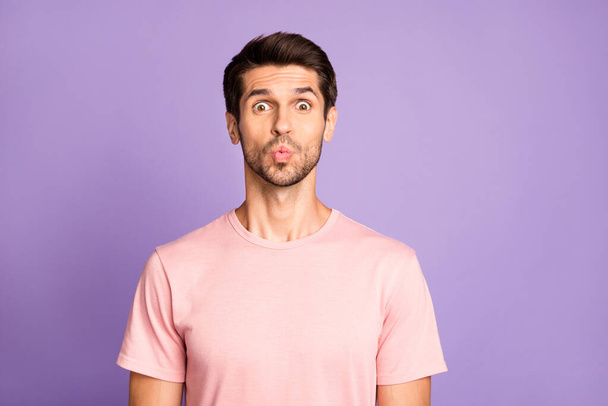 Close-up portrait of his he nice attractive cheerful cheery funky bearded guy wearing pink tshirt pout lips sending kiss fooling isolated over violet purple lilac pastel color background - Fotó, kép